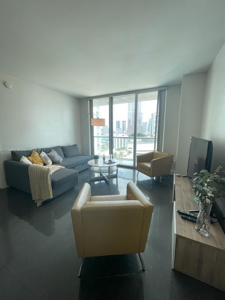 55 Southeast 6th Street, Unit 1903 Miami, FL 33131 - Photo 7 of 23 a living room with furniture and a large window
