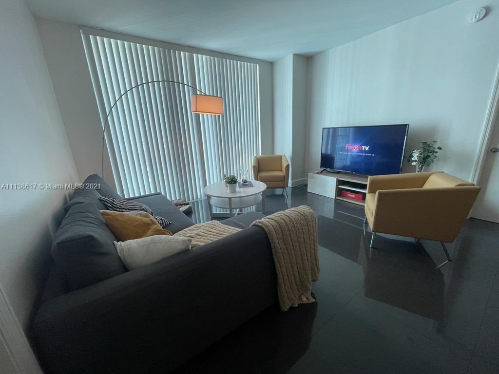 55 Southeast 6th Street, Unit 1903 Miami, FL 33131 - Photo 8 of 23 a living room with furniture and a window