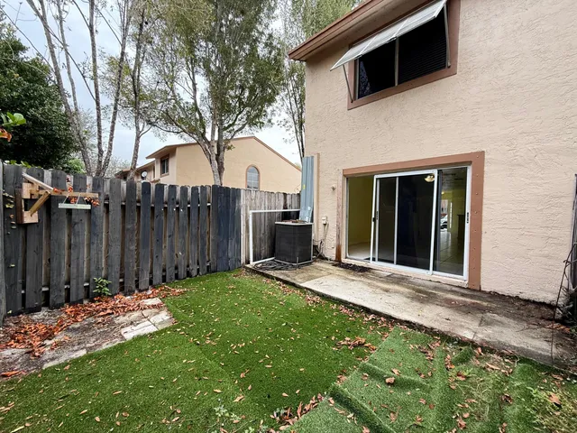 a view of a house with backyard and wooden fence