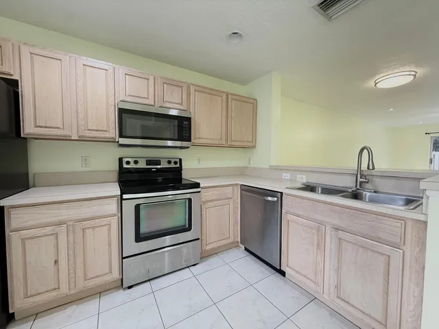 a kitchen with white cabinets appliances and sink