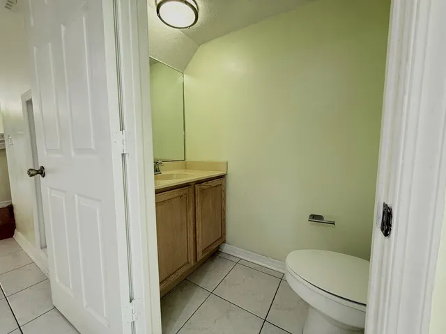 a bathroom with a granite countertop sink a toilet and shower