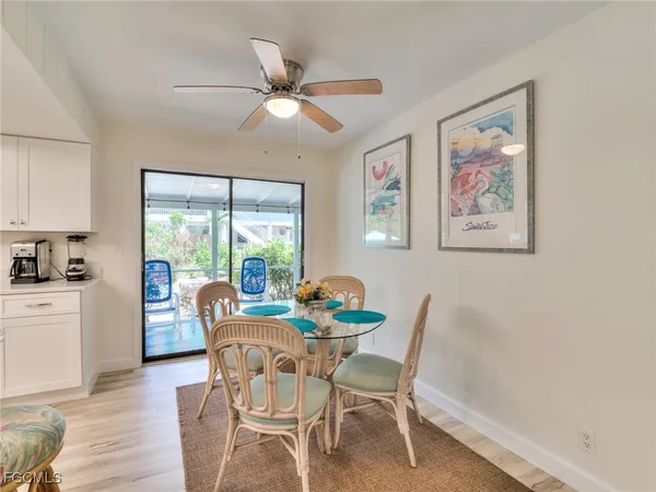 a dining room with furniture a painting on the wall and wooden floor