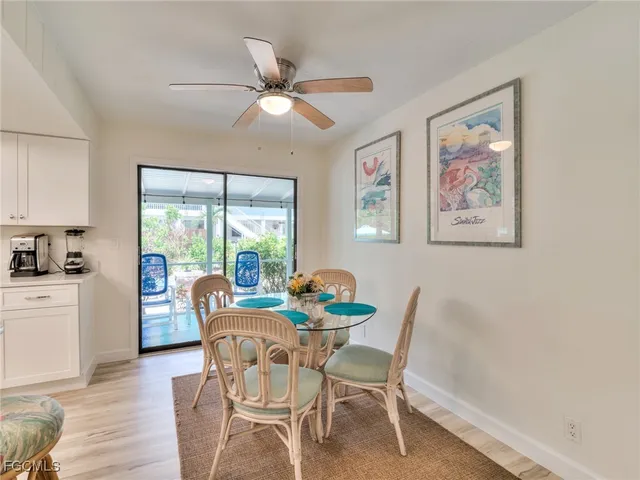 a dining room with furniture a painting on the wall and wooden floor