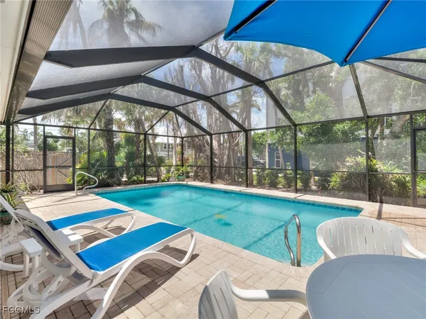 a view of a patio with a table and chairs under an umbrella