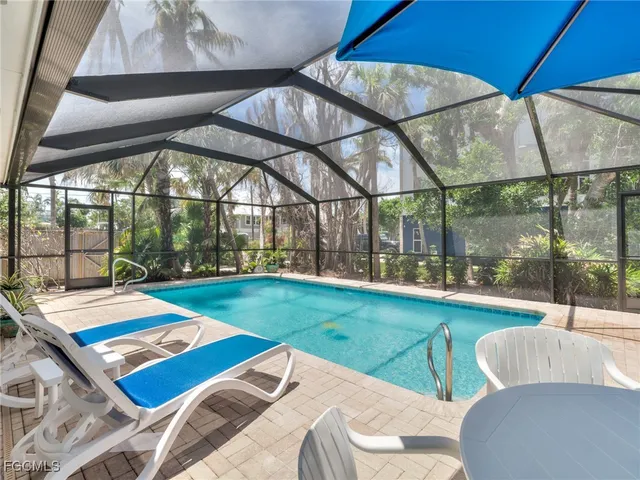 a view of a patio with a table and chairs under an umbrella
