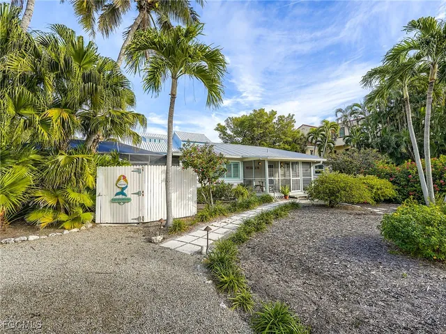 a view of a house with a yard and potted plants