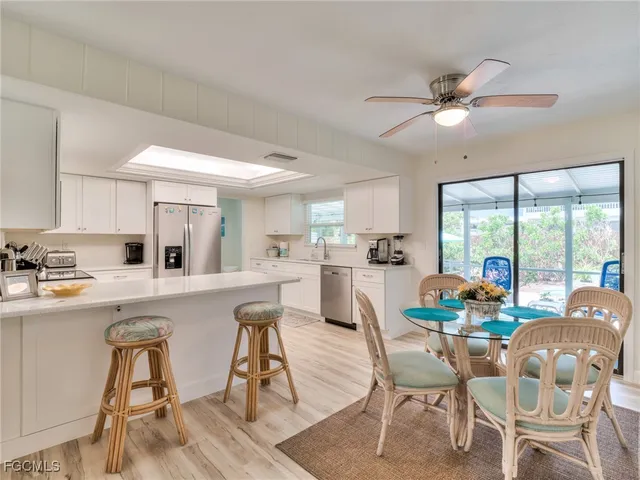 a dining room with furniture a chandelier and wooden floor