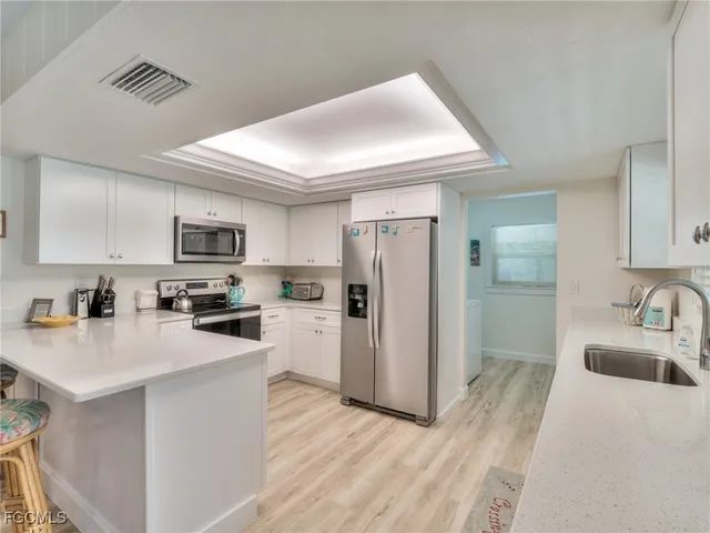 a kitchen with stainless steel appliances a refrigerator a sink a stove a microwave and cabinets