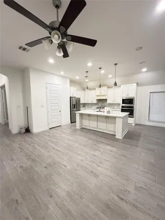 a view of kitchen with kitchen island a stove a sink and a refrigerator