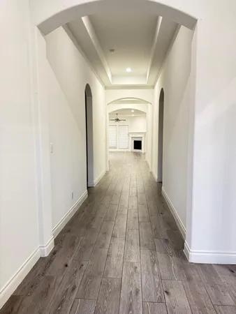 a view of a hallway with wooden floor