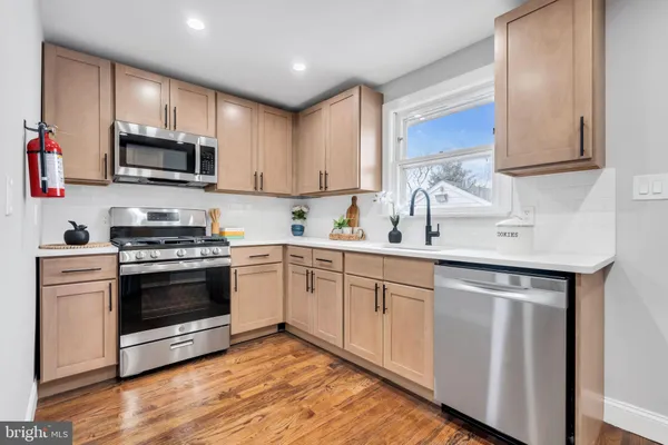 a kitchen with granite countertop a sink cabinets and stainless steel appliances