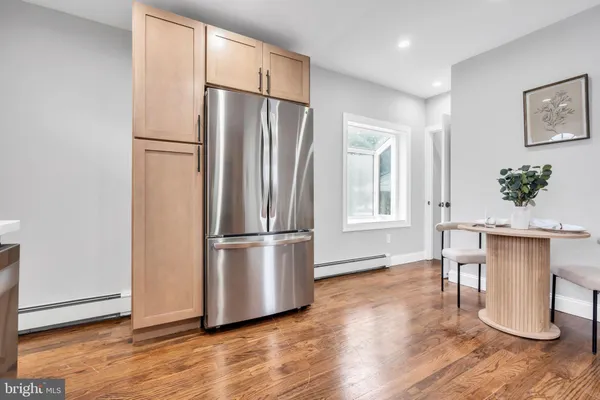 a kitchen with stainless steel appliances a refrigerator and wooden floor