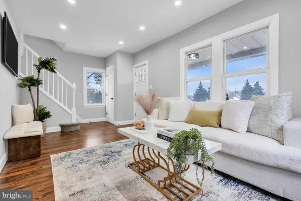 a living room with furniture wooden floor and a flat screen tv