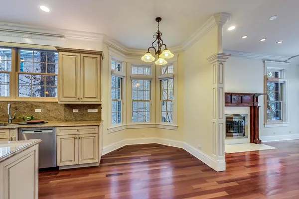 a view of a living room with wooden floor and a fireplace
