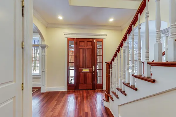 a view of front door with wooden floor and stairs