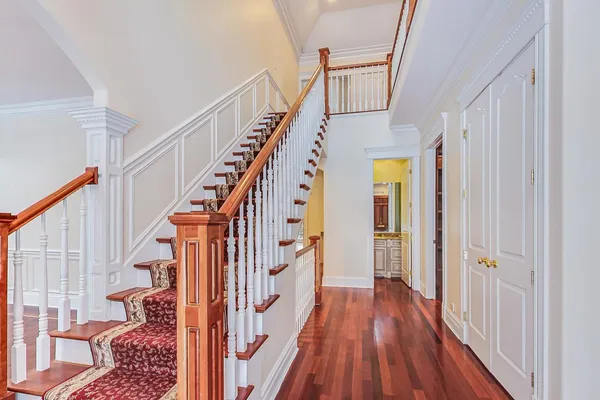 a view of staircase with wooden floor and a chandelier