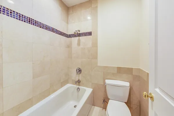 a view of an empty room with wooden floor and windows