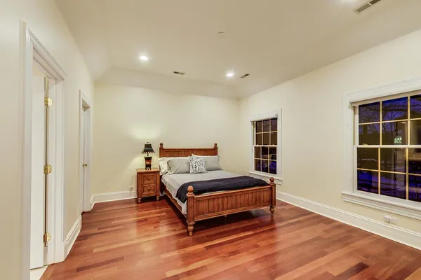 a view of empty room with wooden floor and windows