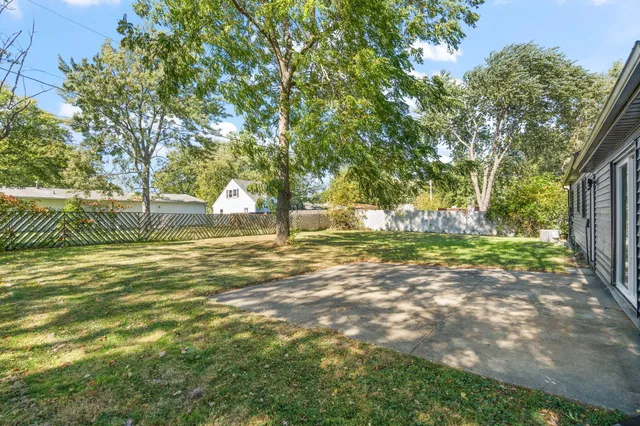 a backyard of a house with lots of green space and fountain