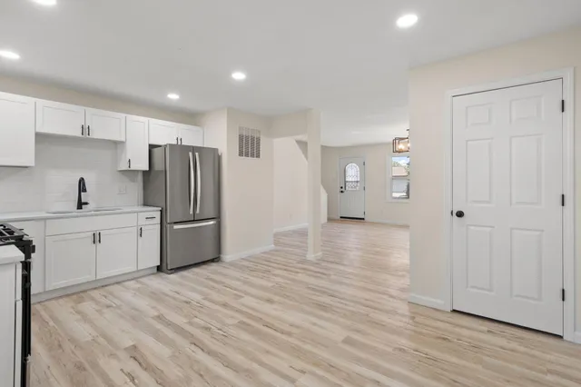 a kitchen with stainless steel appliances a refrigerator and wooden floor