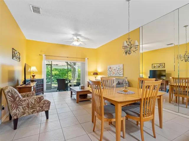 a dining room with furniture and a floor to ceiling window