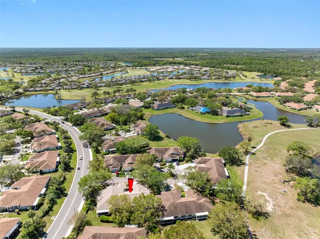 an aerial view of ocean and residential houses with outdoor space