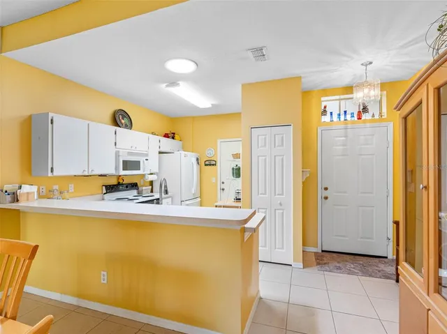 a view of a kitchen with kitchen island a sink a refrigerator and a window