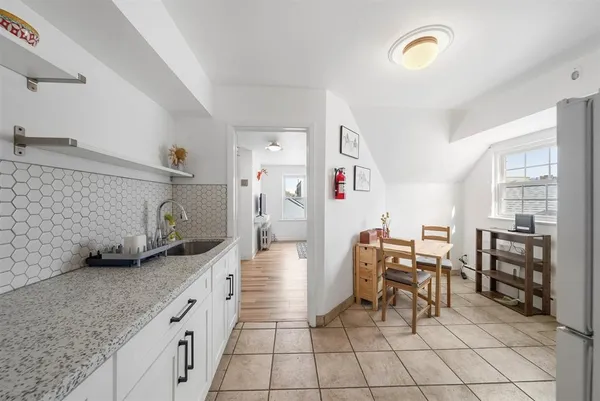 a kitchen with granite countertop cabinets and chairs