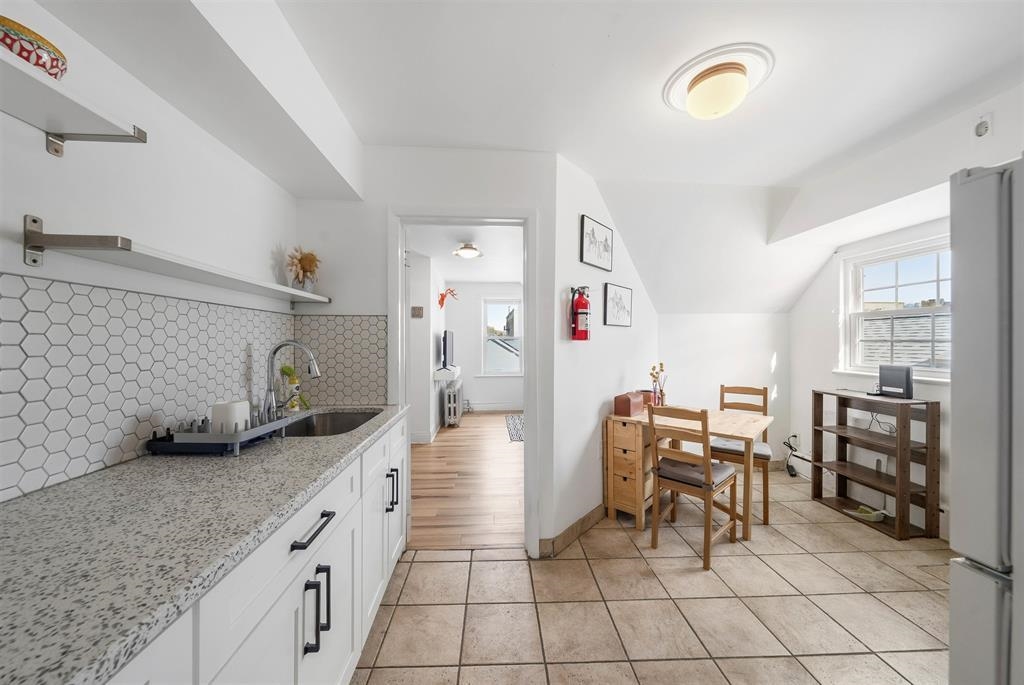 124 73rd Street, Unit 3 North Bergen, NJ 07047 - Photo 12 of 14 a kitchen with granite countertop cabinets and chairs