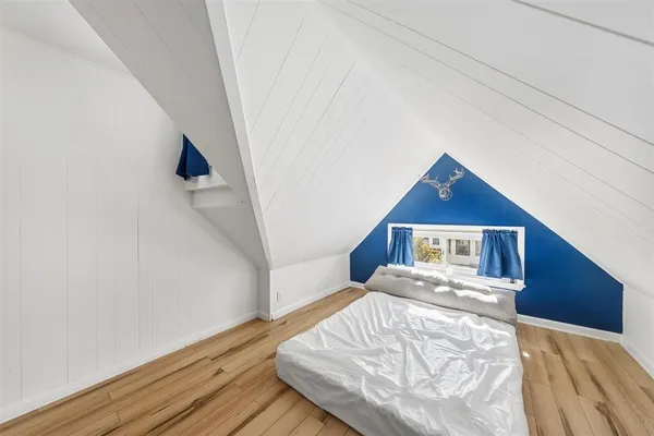 a view of a bedroom with wooden floor and hallway