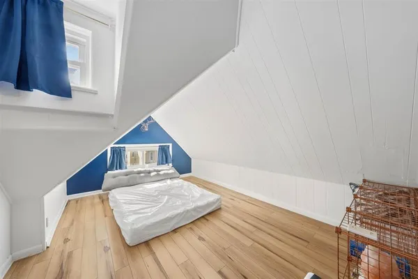 a living room with a bed furniture and a wooden floor