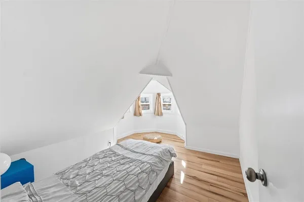 a bedroom with a bed and a wooden floor