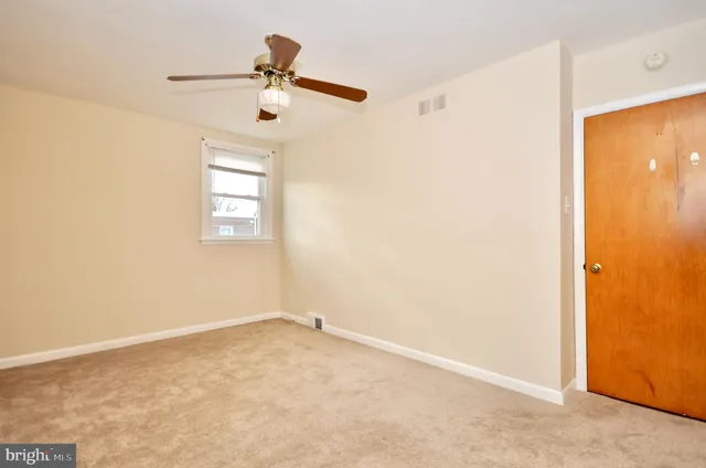 an empty room with windows and ceiling fan