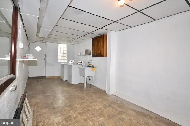 a view of a kitchen with refrigerator and windows