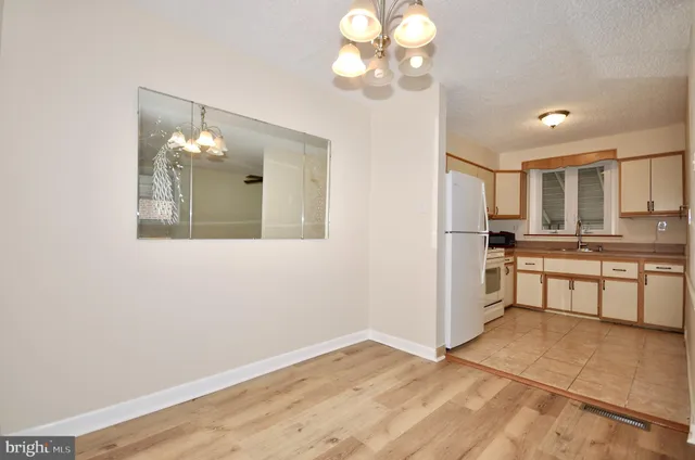 a view of kitchen with granite countertop cabinets and refrigerator