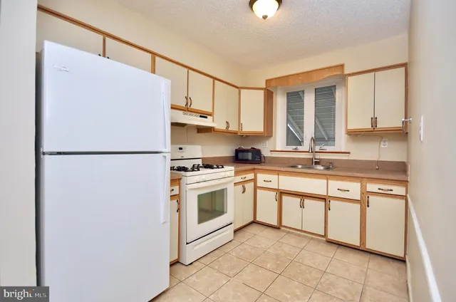 a kitchen with cabinets stainless steel appliances and a window