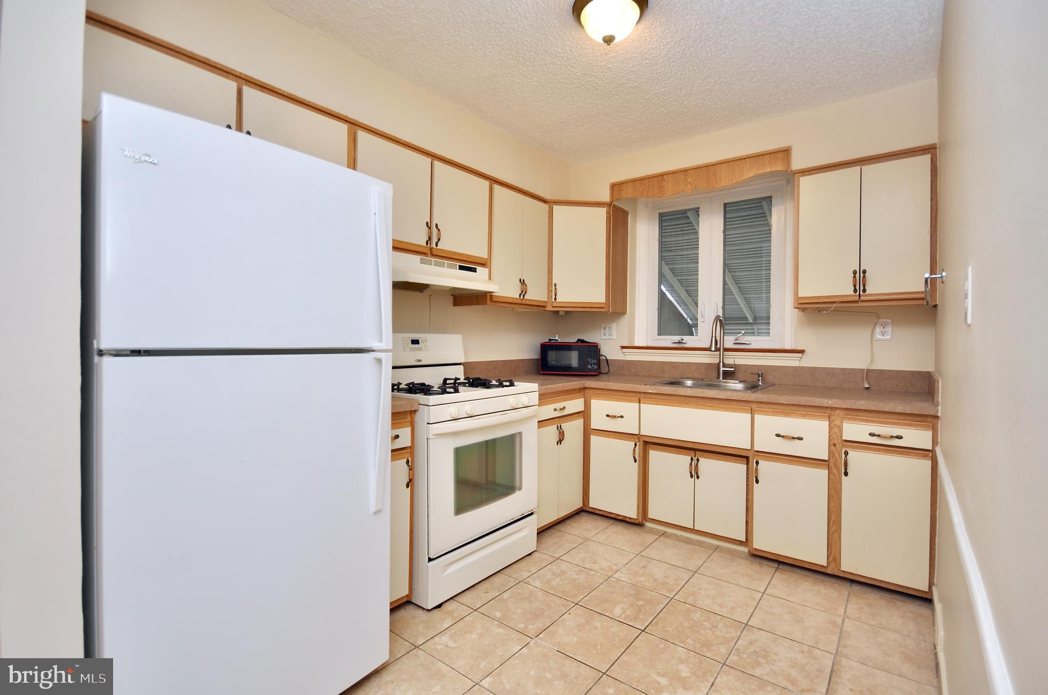 2216 Emerson Street Philadelphia, PA 19152 - Photo 10 of 31 a kitchen with cabinets stainless steel appliances and a window