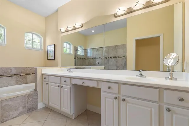a bathroom with a granite countertop sink a mirror and a bathtub