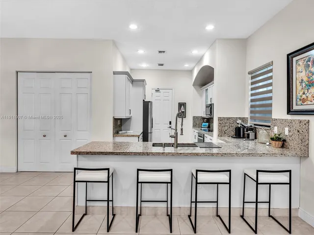 a kitchen with cabinets and chairs