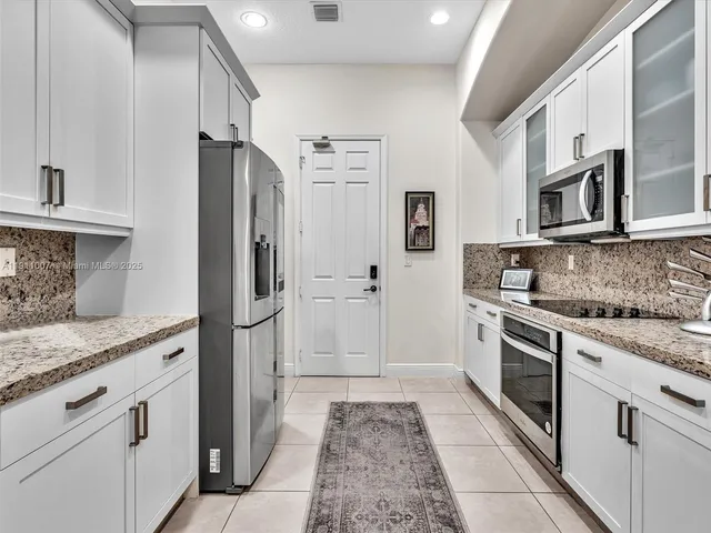 a kitchen with stainless steel appliances granite countertop a refrigerator and a stove