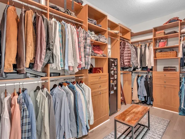 a view of walk in closet with clothes and shoes