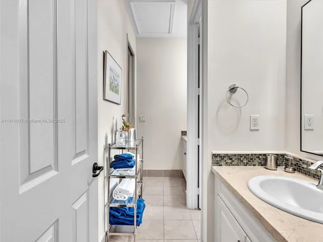 a bathroom with a granite countertop sink a mirror and shower
