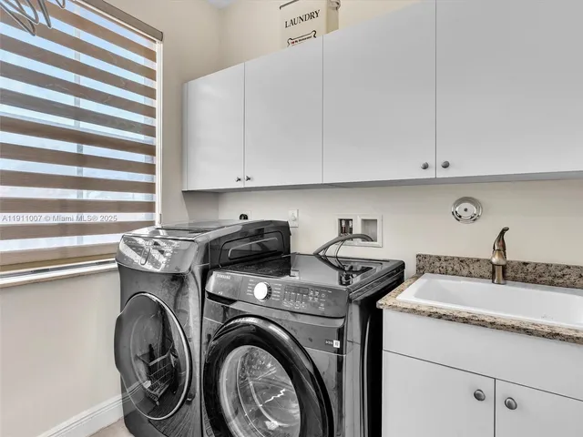 a utility room with sink dryer and washer
