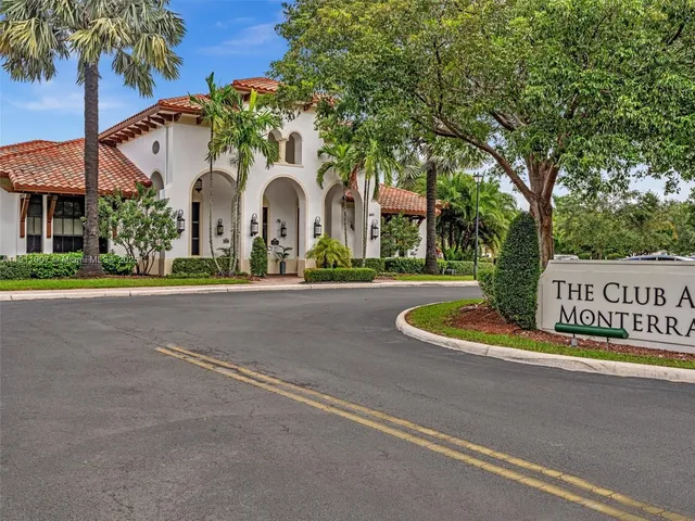 a front view of a house with a garden and trees