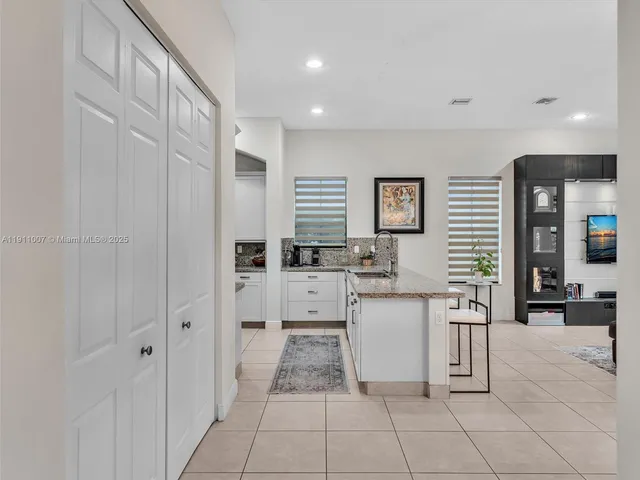 a kitchen with white cabinets and sink