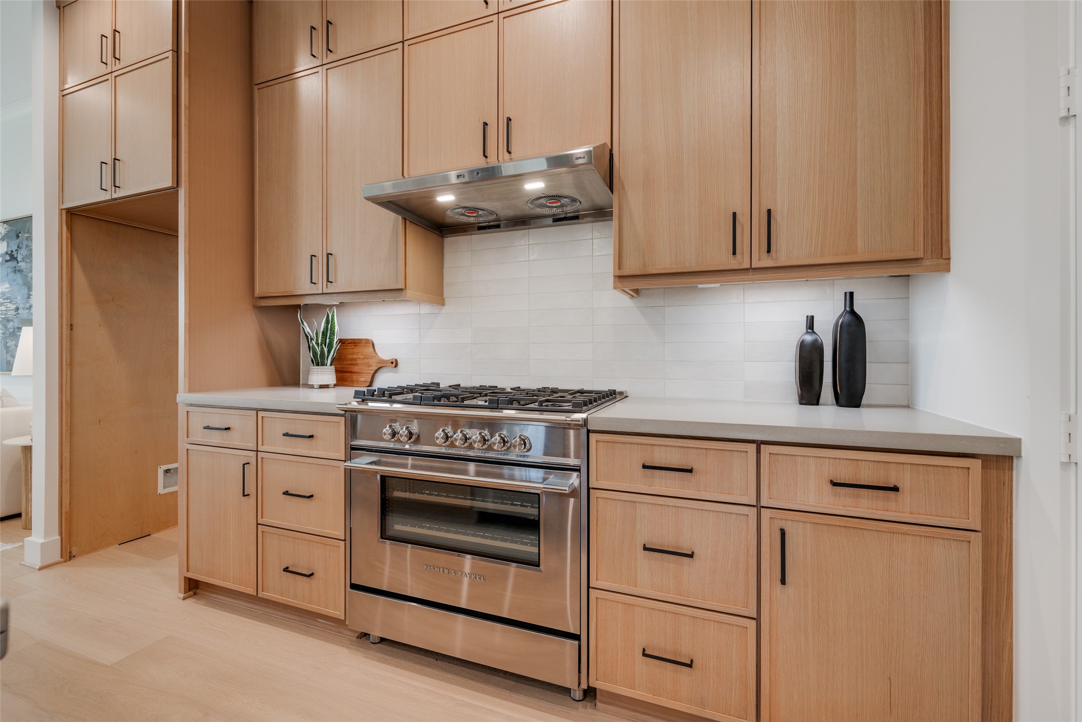 2327 Richton Street Houston, TX 77098 - Photo 14 of 47 a kitchen with white cabinets and a stove with wooden floor