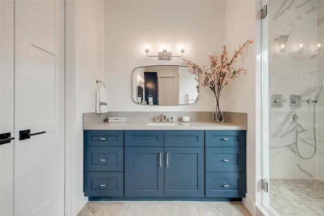 a bathroom with a granite countertop sink a toilet and shower