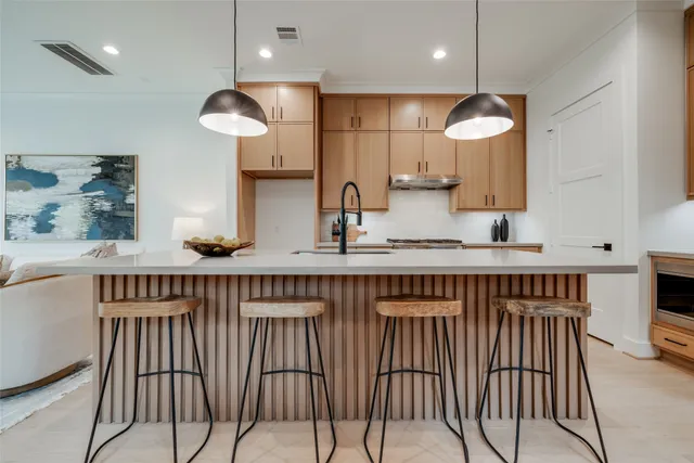 a large kitchen with granite countertop a large kitchen island white cabinets and stainless steel appliances