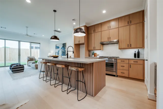a kitchen with white cabinets and a stove with wooden floor
