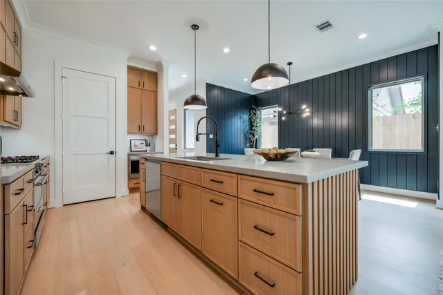 a kitchen with stainless steel appliances a sink a stove top oven a counter space a sink and a refrigerator